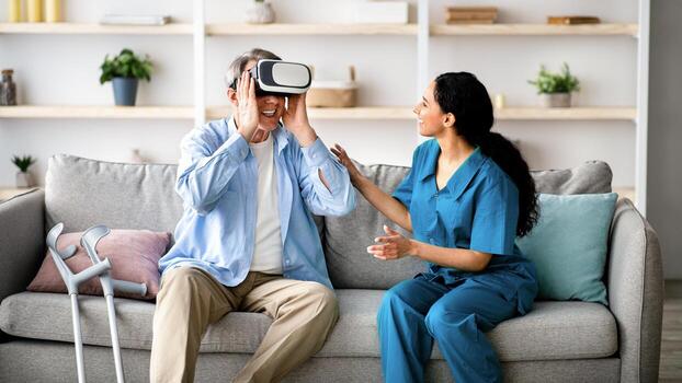 elderly-man-using-vr-headset-with-young-medical-worker-exploring-augmented-reality-at-retirement-home-senior-male-patient-with-caregiver-learning-to-play-virtual-game-having-fun-photo